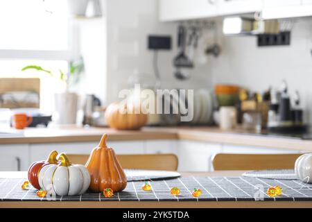 Decorazioni di cucina classica bianca con zucche, ghirlande, latern per Halloween e raccolto con statuetta della casa. Atmosfera autunnale negli interni della casa, moderna Foto Stock