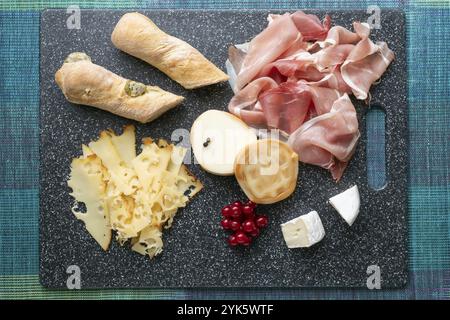 Antipasto freddo. Salumi. Prosciutto, formaggio su tagliere isolato su sfondo blu, vista dall'alto Foto Stock