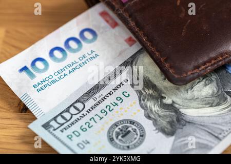 Soldi argentini, peso contro dollaro. Concetto finanziario. Cambio peso in dollari. Nuovi 10.000 mila pesos argentini e 100 dollari USA nel portafoglio. Chiudi Foto Stock