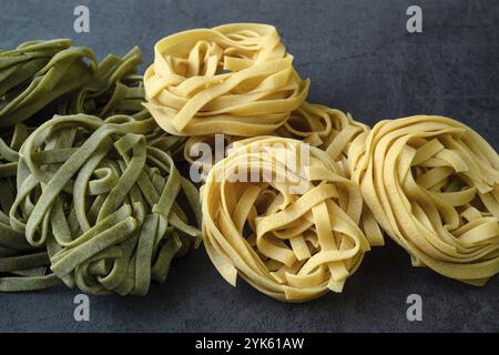 Tagliatelle di pasta verde e gialla fresche fatte in casa. Pasta agli spinaci crudi fatta in casa Foto Stock