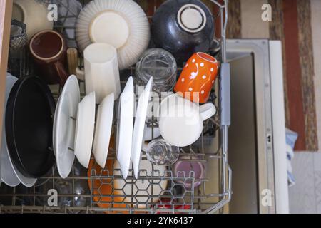 Molti piatti sporchi in lavastoviglie. Aiutare la padrona di casa, l'economia e l'ecologia. Pulizia in cucina Foto Stock