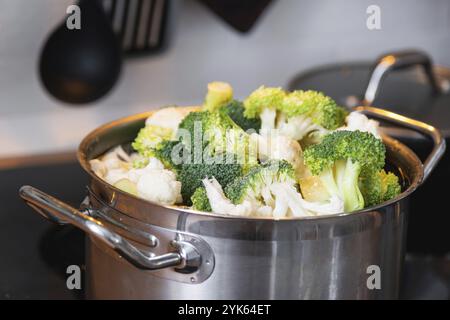 Broccoli e cavolfiore vengono cotti al vapore in una pentola, dieta sana, alimenti per bambini, cottura in una vaporiera Foto Stock