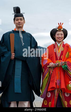 Una coppia di nozze in tradizionale kimono del periodo Heian posa per una foto al Santuario di Itsukushima sull'isola di Miyajima, prefettura di Hiroshima, Giappone. Foto Stock