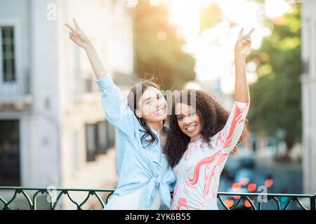 Due amici festeggiano con gioia su una strada soleggiata alla luce della sera Foto Stock