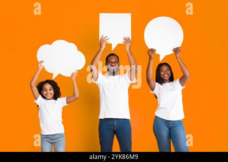 Sorridente famiglia nera che ha in studio diverse bolle di discorso Foto Stock