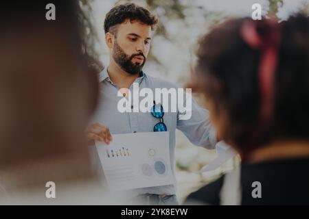 Uomini d'affari che discutono grafici e diagrammi all'aperto Foto Stock