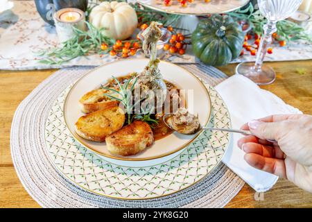 Zuppa di anatra arrostita con pane all'aglio su un piatto e un piatto di porcellana e un cucchiaio d'argento per la cena del Ringraziamento. Foto Stock