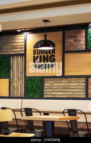 Bielorussia, Minsk - 18 luglio 2024: Un ristorante Burger King che dispone di una disposizione di tavoli e sedie, progettato per il comfort dei clienti durante la cena Foto Stock