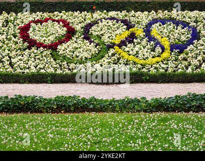 Rennes, Francia - 26 luglio 2024: Una vivace mostra floreale con gli anelli olimpici realizzati con fiori colorati, sullo sfondo di una fioritura bianca Foto Stock