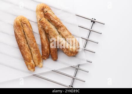 Cibo appena sfornato, dolci salati su Metal rack, torta al formaggio greco o banitsa al burro bulgaro per colazione Foto Stock