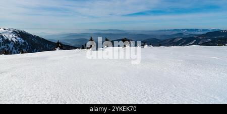 Kralicky Sneznik e molte altre colline dalla collina Jeleni hrbet sopra Jeleni studanka nelle montagne Jeseniky nella repubblica Ceca durante la splendida giornata invernale Foto Stock