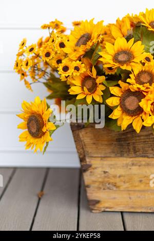 Cestino di girasoli in legno sul portico anteriore Foto Stock