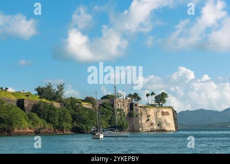 Fort-de-France, Martinica - 3 gennaio 2018: Una vista panoramica di Fort Saint Louis dalla baia con una barca a vela ancorata in acque calme. Foto Stock