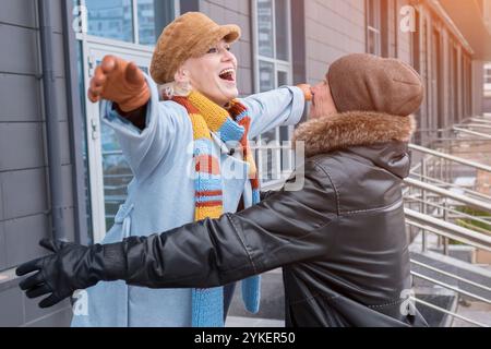 Felice coppia di anziani che abbraccia all'aperto con abiti invernali Foto Stock