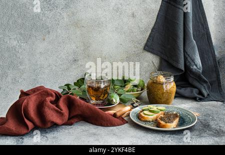 Un ambiente accogliente caratterizzato da tè floreale con panini, conditi con marmellata di feijoa fresca e circondati da frutta feijoa matura, l'ambiente trasuda calore, creato Foto Stock