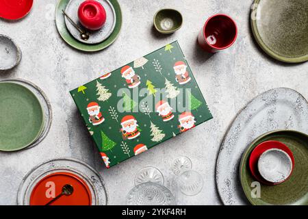 Vista dall'alto di un tavolo in ceramica disposto ad arte, caratterizzato da piatti e ciotole assortiti con finitura testurizzata, completati da una vibrante Christma Foto Stock