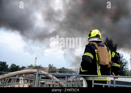 Domani, 19 novembre 2024 l'Ucraina sarà in guerra da 1000 giorni. Servizi di emergenza in loco a Kiev dopo gli attacchi missilistici russi in Ucraina, fumo denso che sale dal fuoco sullo sfondo, immagine scattata il 2 settembre 2024. Foto Stock