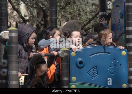 Gli studenti ebrei ortodossi della yeshivah trascorrono una pausa in un parco giochi a Brooklyn, New York. Foto Stock