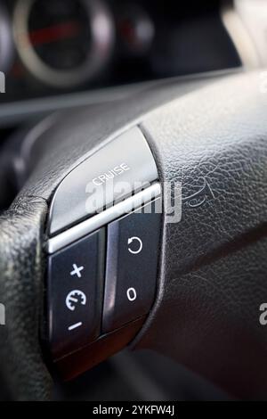 Pulsanti di comando sul volante. Interni SUV per auto. Dettaglio auto, primo piano dell'interruttore del controllo della velocità di crociera con messa a fuoco selettiva Foto Stock