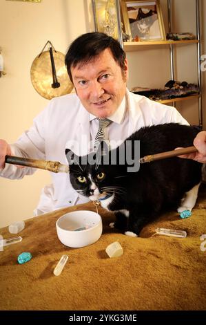 Un medico curante di cristalli che tratta un gatto nero. Foto Stock