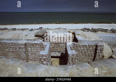 Prima guerra del Golfo: 11 marzo 1991 una trincea irachena abbandonata sulla spiaggia di Ali Baba in Kuwait City. Aspettandosi che le forze della coalizione invadano dal mare, il filo spinato e le difese anti-sbarco erano appese lungo la spiaggia e nelle basse acque, vicino alla riva. Anche le spiagge erano minate. Foto Stock