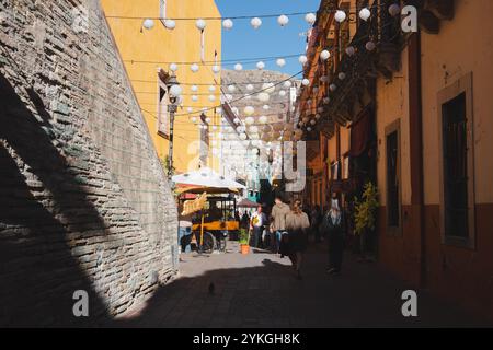 Guanajuato, Messico - 4 febbraio 2024: Un vivace e vivace vicolo nella città vecchia di Guanajuato con lanterne decorative appese e luci festose, dove Foto Stock