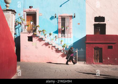 Guanajuato, Messico - 4 febbraio 2024 Una vivace scena nella storica città vecchia di Guanajuato, caratterizzata da un edificio coloniale spagnolo color rosa pastello e blu Foto Stock