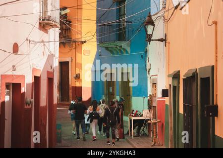 Guanajuato, Messico - 4 febbraio 2024: Una vivace via secondaria a Guanajuato, Messico, con colorati edifici coloniali, dove la gente del posto e gli adolescenti si divertono Foto Stock