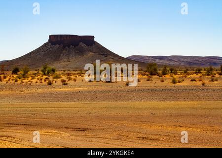 Deserto di pietra secca e montagna solitaria sullo sfondo. Marocco Foto Stock