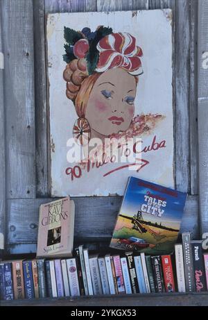 A 90 km circa da Cuba poster con una ragazza ispanica che indossa una testata di frutta a Key West che indica Cuba. Florida. STATI UNITI Foto Stock