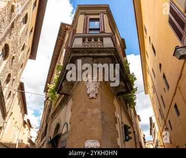 Firenze, Italia - 31 maggio 2024: Stretta casa d'angolo all'incrocio di due strade a Firenze. Vista dal basso verso l'alto. Foto Stock
