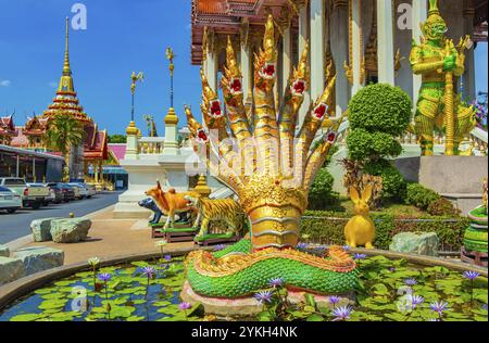 Statue di draghi dorati e verdi di pesci drago nel coloratissimo tempio buddista Wat Don Mueang Phra Arramluang a Bangkok in Thailandia Foto Stock