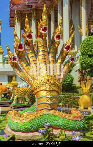 Statue di draghi dorati e verdi di pesci drago nel coloratissimo tempio buddista Wat Don Mueang Phra Arramluang a Bangkok in Thailandia Foto Stock