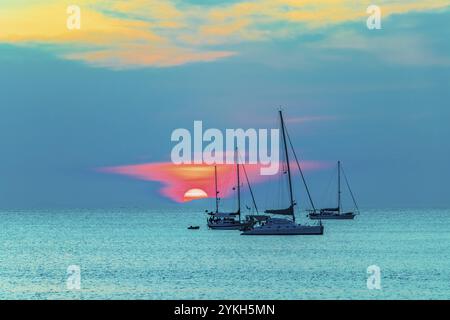 Yacht di fronte al tramonto più bello e colorato sull'isola Tropical Paradise Koh Phayam Ao Khao Kwai Beach a Ranong, Thailandia Foto Stock