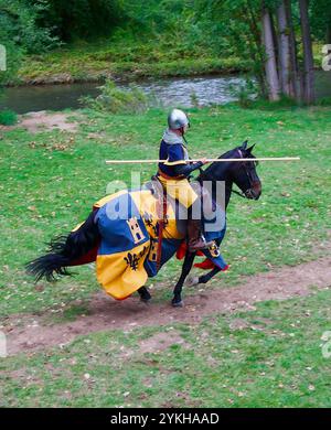 Uomo in costume medievale cavalca un cavallo capitanato durante una rievocazione storica di un torneo medievale durante le feste di El Cid a Burgos in Spagna Foto Stock