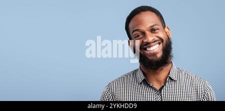 Sorridente ritratto di uomo afro su sfondo blu Foto Stock