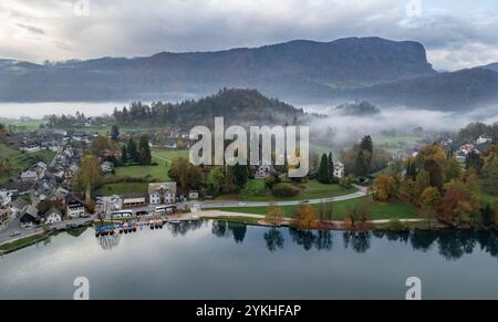 La valle del lago Bled è abbracciata dalla nebbia durante la stagione autunnale delle foglie Foto Stock