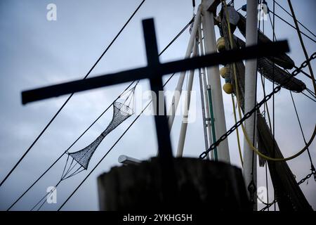 Cuxhaven, Germania. 18 novembre 2024. Una croce è collocata al porto di fronte alle imbarcazioni per gamberetti. La seconda Conferenza della pesca della Germania settentrionale si svolge a Cuxhaven. Il tema della conferenza è la salvaguardia e lo sviluppo sostenibile della pesca costiera tedesca. Credito: Sina Schuldt/dpa/Alamy Live News Foto Stock