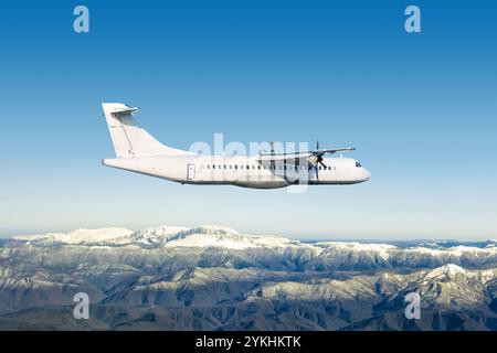 L'aereo turboelica bianco passeggeri sorvola montagne innevate Foto Stock