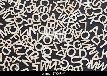 Potete vedere nell'immagine le lettere di legno su uno sfondo della lavagna, disposte in modo casuale Foto Stock