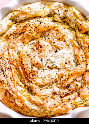 Torta tradizionale di pasta fillo al formaggio feta su sfondo bianco. vista dall'alto Foto Stock