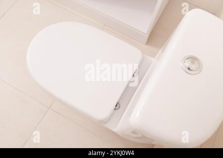 Ciotola bianca per WC. Vista dall'alto, primo piano. Combattere gli odori sgradevoli del bagno fresco. Deodorante per WC con oli aromatici altamente concentrati Foto Stock