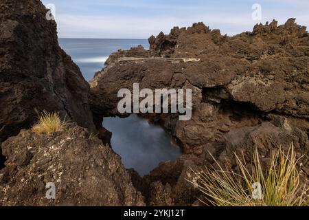 Cachorro con le sue case tradizionali e le formazioni rocciose di lava si trova sulla costa della parrocchia di Bandeiras, nel comune di Madalena, Pi Foto Stock