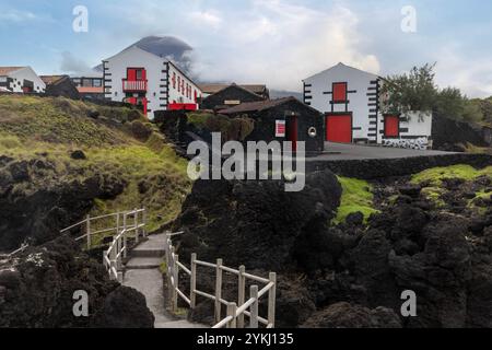 Cachorro con le sue case tradizionali e le formazioni rocciose di lava si trova sulla costa della parrocchia di Bandeiras, nel comune di Madalena, Pi Foto Stock