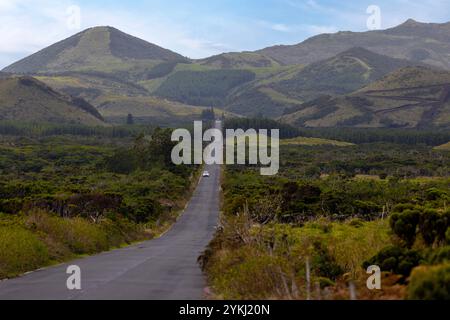 Un viaggio su strada lungo la strada rettilinea più lunga del Portogallo con vista sul monte Pico e sulla catena montuosa delle Azzorre. Foto Stock