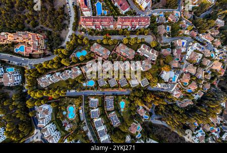 Questa immagine mostra un'area residenziale con case annidate tra alberi. Presenta una serie di strade tortuose e diverse piscine blu. Le case Foto Stock