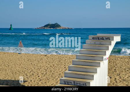 Sokcho, Corea del Sud - 3 novembre 2024: Scale di legno che conducono verso il mare sulla spiaggia di Sokcho con l'Isola di Jodo visibile sullo sfondo. Un tranquillo Foto Stock