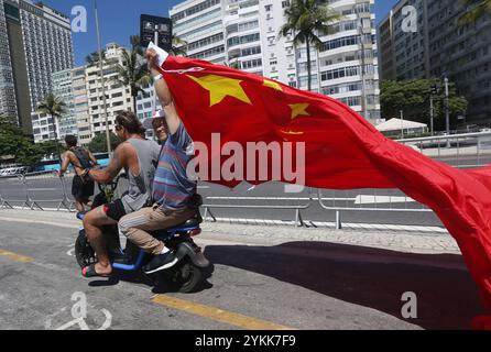 Rio De Janeiro, Brasile. 18 novembre 2024. Un uomo sventola una bandiera cinese dal retro di uno scooter a Copacabana. I leader delle più grandi economie del mondo si stanno riunendo in Brasile per il vertice del G20 che ha preso il via lunedì. (Immagine di credito: © Bob Karp/ZUMA Press Wire) SOLO PER USO EDITORIALE! Non per USO commerciale! Foto Stock