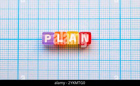 Blocchi colorati con testo "piano" su sfondo di carta rivestito Foto Stock