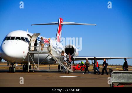 I turisti salgono a bordo di un Boeing 717 Qantas Link sull'asfalto all'aeroporto di Alice Springs Foto Stock